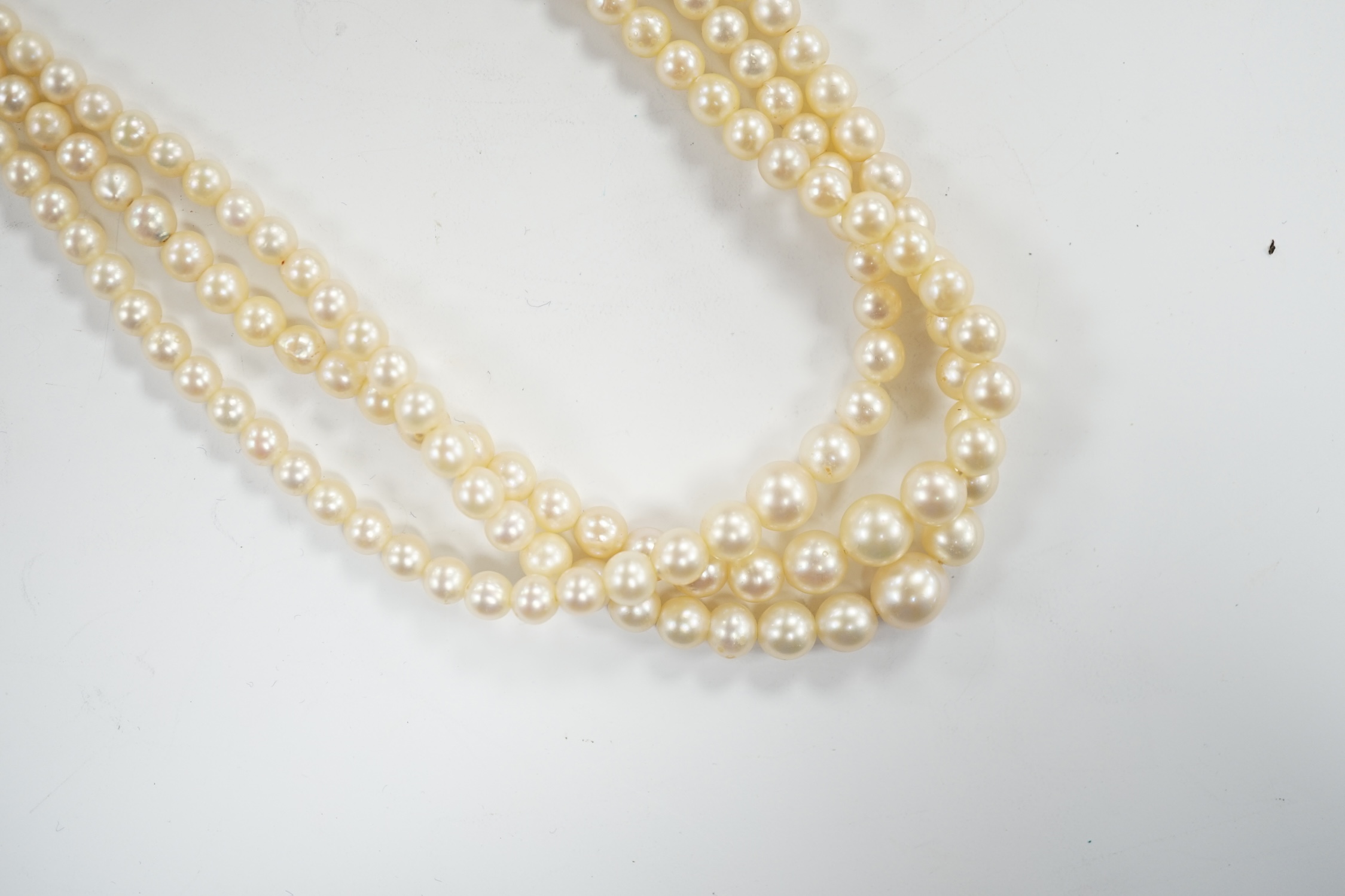 A triple strand graduated cultured pearl choker necklace, with diamond chip set 9ct white gold clasp, 38cm, in a Harrods box, together with some loose beads.